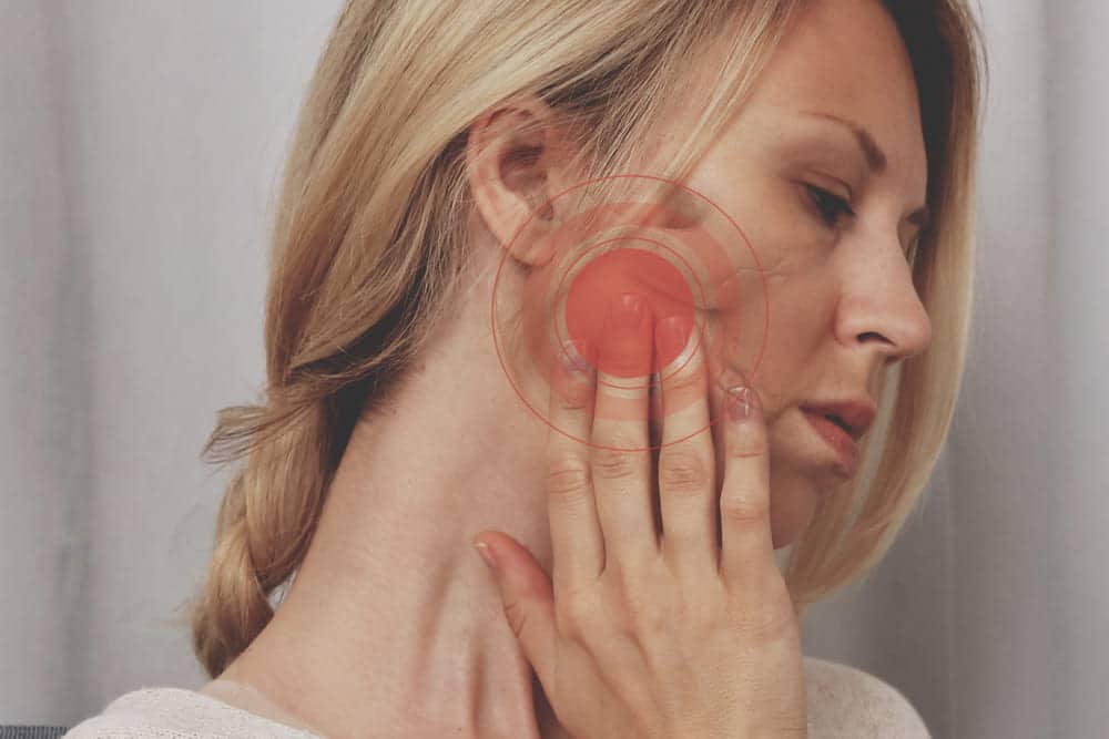 mujer con dolor articulación temporomandibular