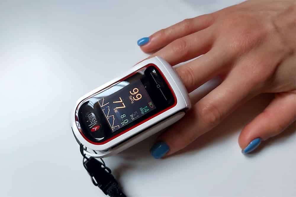 mano con pulsioxímetro